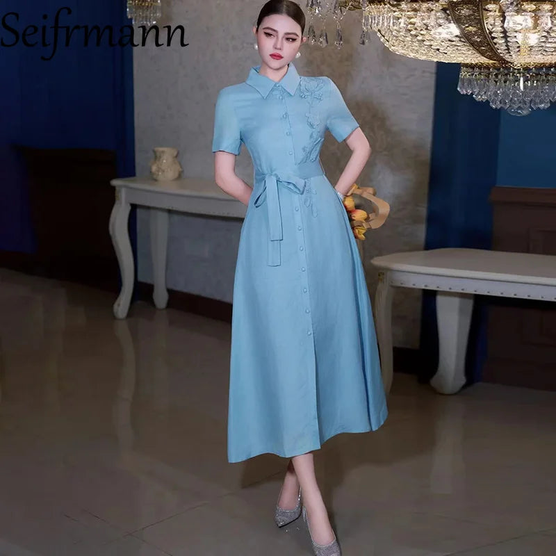 Nouvelle robe longue femme tendance été 2026 Seifrmann à revers, manches courtes, simple boutonnage, avec ceinture et taille cintrée